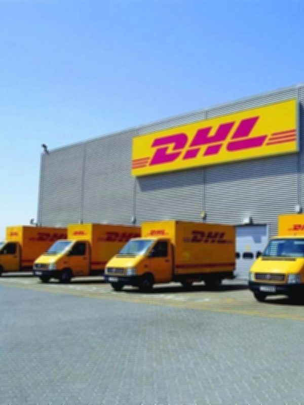 DHL Express truck fleet at distribution hub for international door-to-door delivery