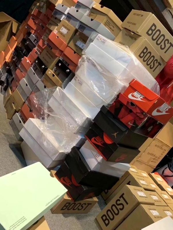 Multi-brand shoe box inventory stacked at factory warehouse